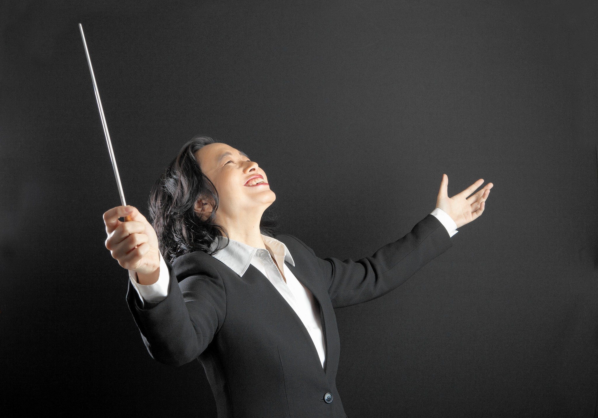 Carolyn Kuan conducting, with baton raised